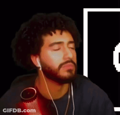 A Man With A Beard Is Wearing Ear Buds And A Microphone GIF