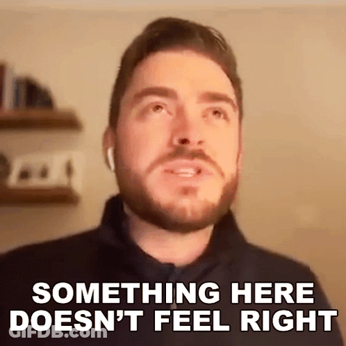 A Man With A Beard Is Wearing Ear Buds And Saying Something Here Does N't Feel Right . GIF