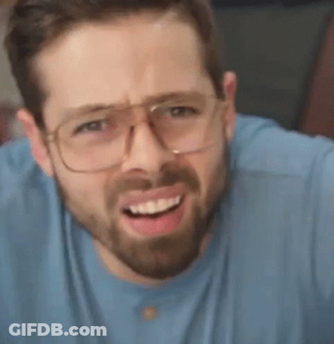 A Man With A Beard Is Wearing Glasses And Making A Funny Face . GIF