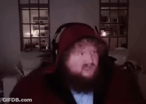 A Man With A Beard Is Wearing Headphones And A Hoodie . GIF