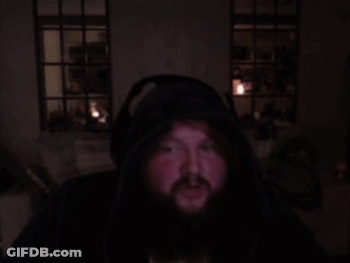 A Man With A Beard Is Wearing Headphones And A Hoodie GIF