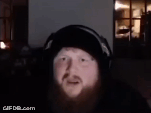 A Man With A Beard Is Wearing Headphones And Has The Words What Is That Supposed To Mean Above Him GIF