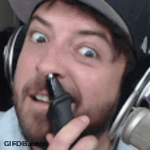 A Man With A Beard Is Wearing Headphones And Holding A Microphone In His Hand . GIF