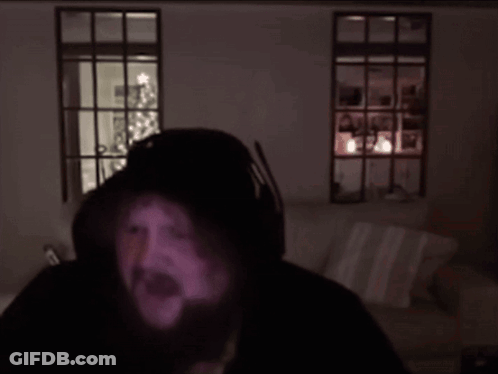 A Man With A Beard Is Wearing Headphones And Looking At The Camera GIF