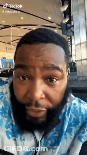A Man With A Beard Is Wearing Headphones And Looking At The Camera GIF