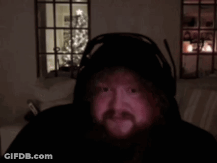 A Man With A Beard Is Wearing Headphones And Looking At The Camera . GIF