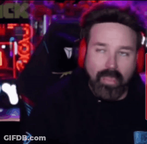 A Man With A Beard Is Wearing Headphones And Looking At The Camera GIF