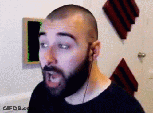 A Man With A Beard Is Wearing Headphones And Making A Face . GIF
