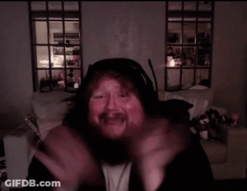 A Man With A Beard Is Wearing Headphones And Making A Face GIF