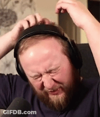 A Man With A Beard Is Wearing Headphones And Making A Face . GIF