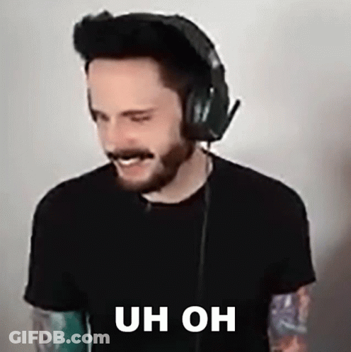 A Man With A Beard Is Wearing Headphones And Making A Face . GIF