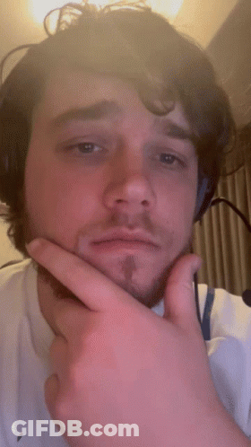 A Man With A Beard Is Wearing Headphones And Making A Funny Face GIF