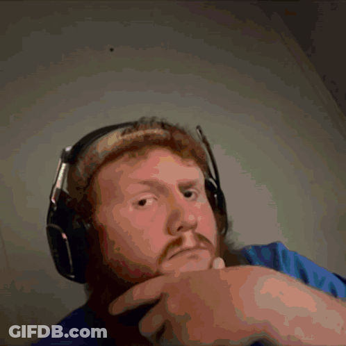 A Man With A Beard Is Wearing Headphones And Making A Funny Face GIF