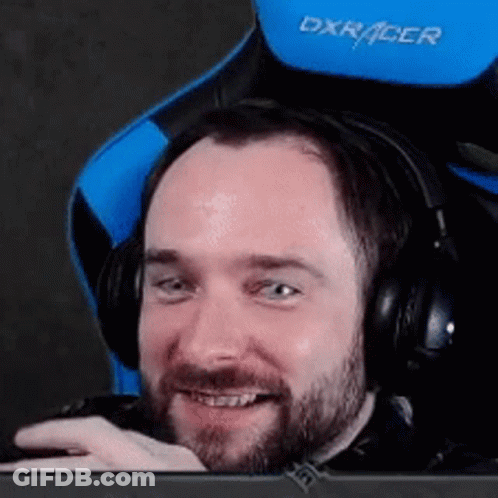 A Man With A Beard Is Wearing Headphones And Sitting In A Blue And Black Chair . GIF