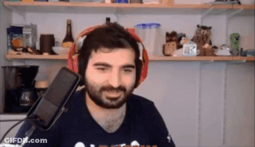 A Man With A Beard Is Wearing Headphones In Front Of A Microphone And Smiling GIF