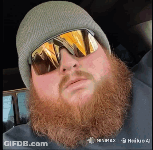 A Man With A Beard Is Wearing Sunglasses And A Hat GIF