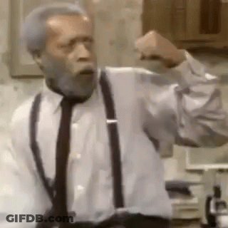 A Man With A Beard Is Wearing Suspenders And A Tie And Is Making A Fist . GIF
