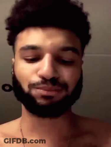 A Man With A Beard Is Without A Shirt And Is Looking Down . GIF