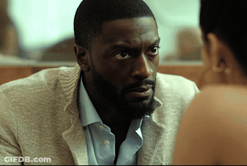 A Man With A Beard Looks At A Woman With A Serious Look On His Face GIF