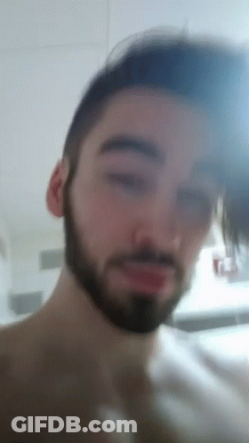 A Man With A Beard Looks At The Camera GIF