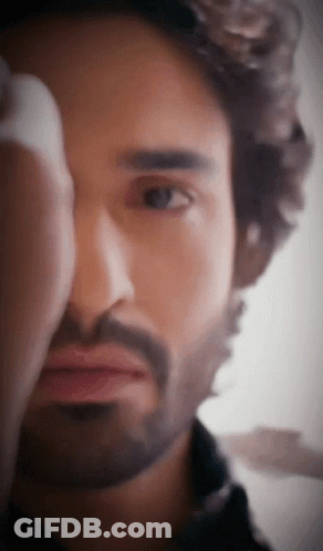 A Man With A Beard Looks At The Camera GIF