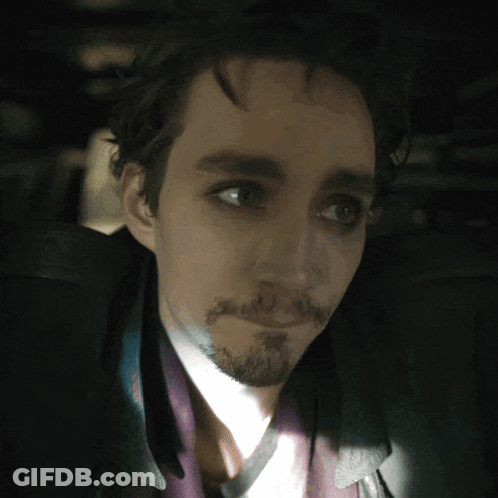 A Man With A Beard Looks At The Camera GIF