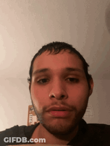 A Man With A Beard Looks At The Camera With A Serious Look On His Face GIF