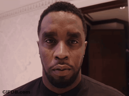 A Man With A Beard Looks At The Camera With A Serious Look On His Face GIF