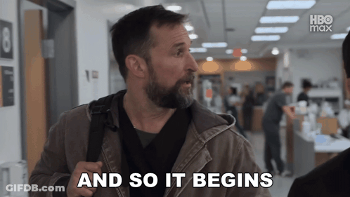 A Man With A Beard Says " And So It Begins " In A Hallway GIF