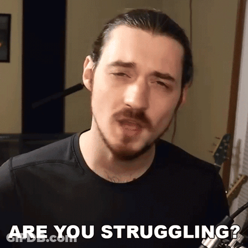 A Man With A Beard Says " Are You Struggling " In Front Of A Microphone GIF