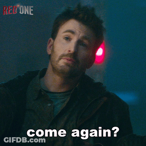 A Man With A Beard Says Come Again In Front Of A Red Light GIF