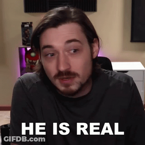 A Man With A Beard Says He Is Real In Front Of A Desk GIF