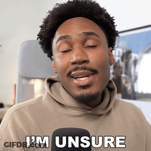 A Man With A Beard Says I 'M Unsure In Front Of A Microphone GIF