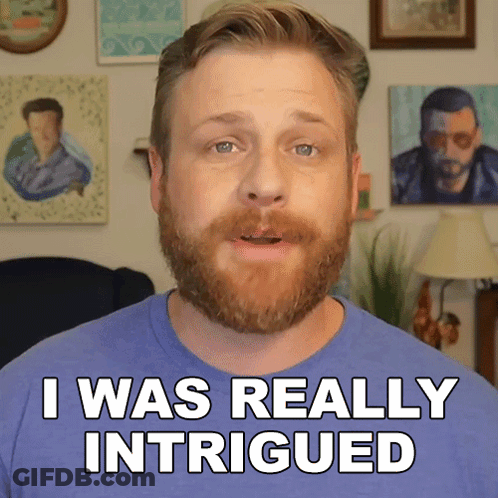 A Man With A Beard Says " I Was Really Intrigued " In Front Of Some Paintings GIF