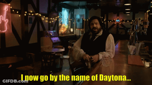A Man With A Beard Says Jackie Daytona In A Dark Room GIF