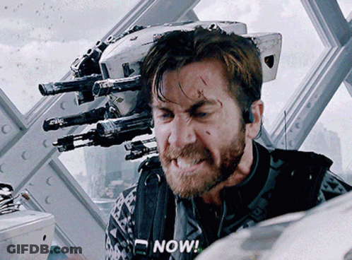 A Man With A Beard Says Now In Front Of A Robot GIF