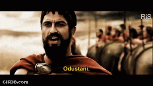 A Man With A Beard Says " Odustani " In Front Of A Crowd GIF