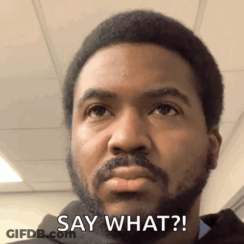 A Man With A Beard Says " Say What " In Front Of His Face GIF