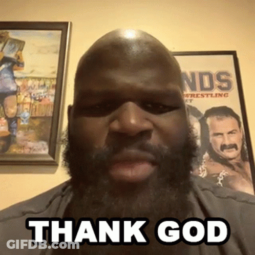 A Man With A Beard Says " Thank God " In Front Of A Wrestling Poster GIF
