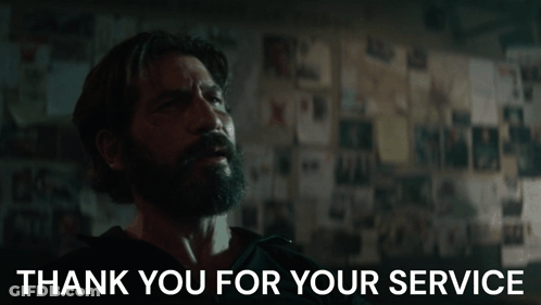 A Man With A Beard Says Thank You For Your Service In Front Of A Wall GIF