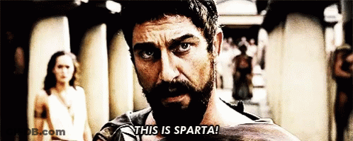 A Man With A Beard Says " This Is Sparta " In Front Of A Woman GIF