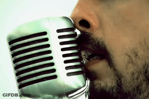 A Man With A Beard Singing Into A Silver Microphone GIF