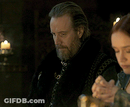 A Man With A Beard Sits At A Table With A Woman GIF