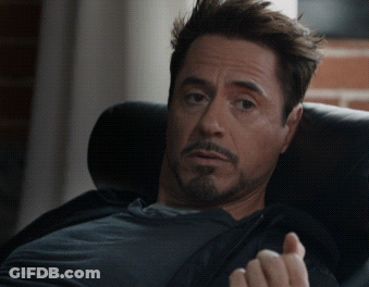A Man With A Beard Sits In A Chair With His Hand Out GIF