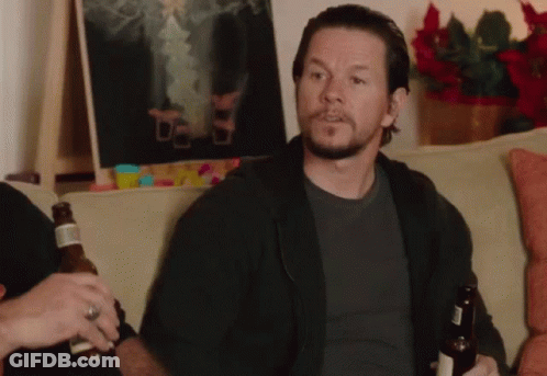 A Man With A Beard Sits On A Couch Holding A Bottle Of Beer GIF
