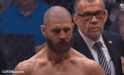 A Man With A Beard Stands In Front Of A Man In A Suit GIF