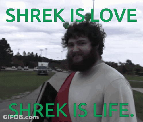 A Man With A Beard Stands In Front Of A Sign That Says Shrek Is Love And Shrek Is Life GIF