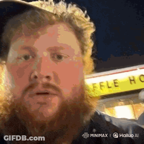A Man With A Beard Stands In Front Of A Waffle House Sign GIF