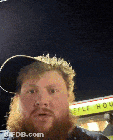A Man With A Beard Stands In Front Of A Waffle House Sign GIF