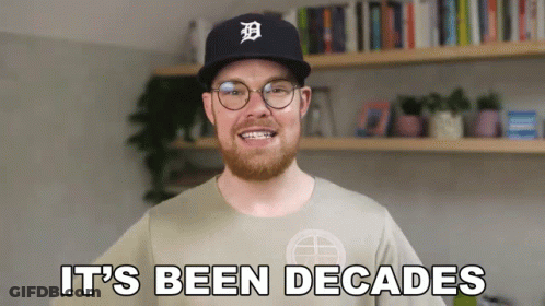 A Man With A Beard Wearing A Baseball Cap And Glasses Says It 'S Been Decades GIF